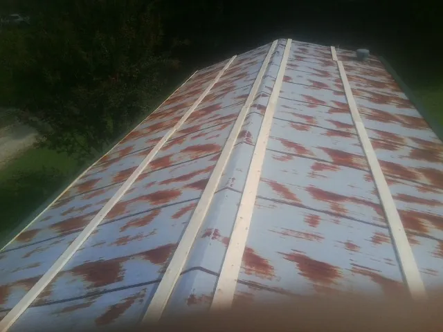 Rusted metal roof panels with new wood purlins before replacement — Storm Damage Roof Repair in Canmer by Roofing Brothers