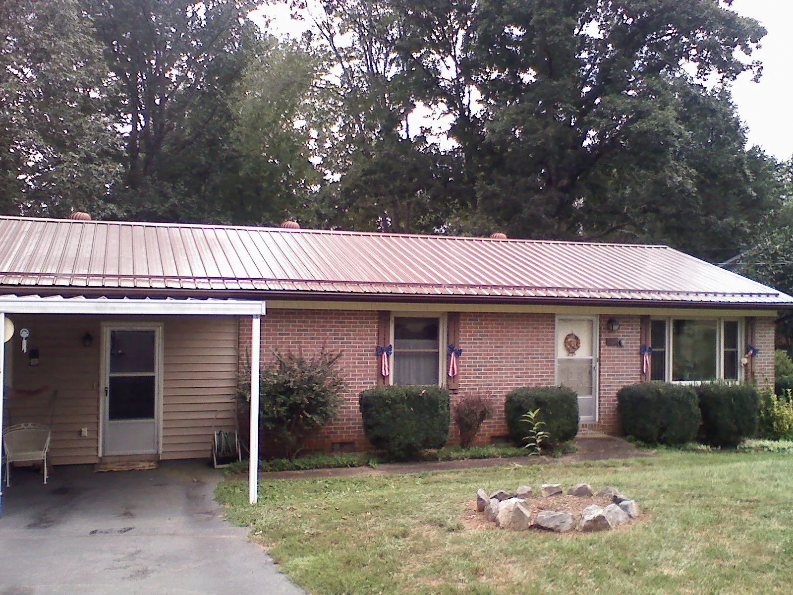 Bronze metal roof and carport on a brick ranch home — Roof Repair work by our crew in Canmer